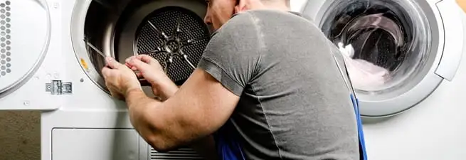 Dryer repair technician fixing a clothes dryer drum in El Paso, TX