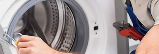 Appliance technician repairing a clothes dryer drum and internal parts in El Paso, TX
