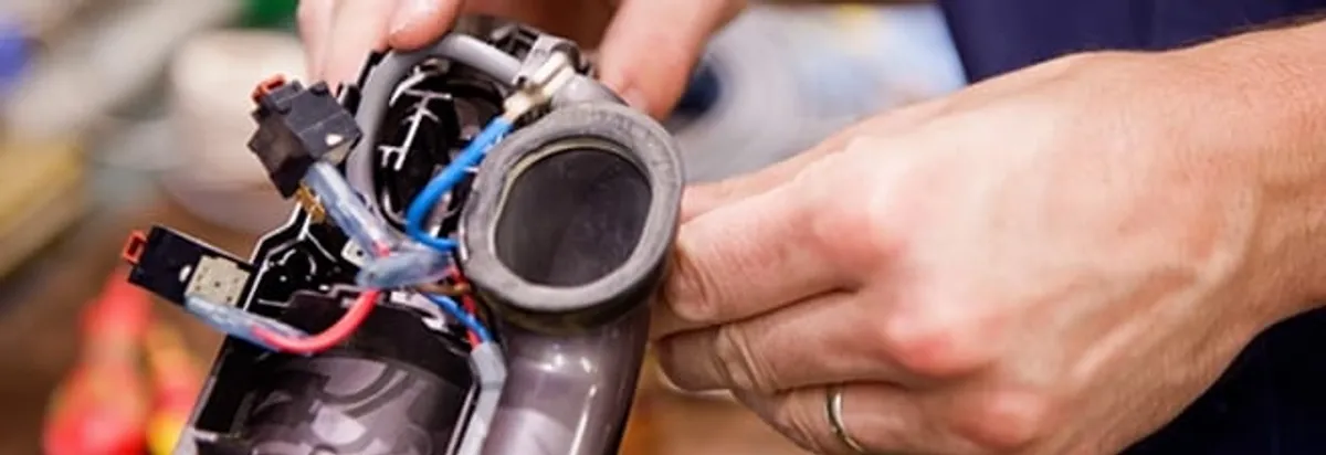 Vacuum repair technician reconnecting wiring and components in El Paso, TX